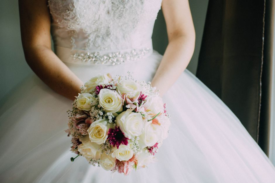 Bride holding floral bouquet coordinated by wedding professionals